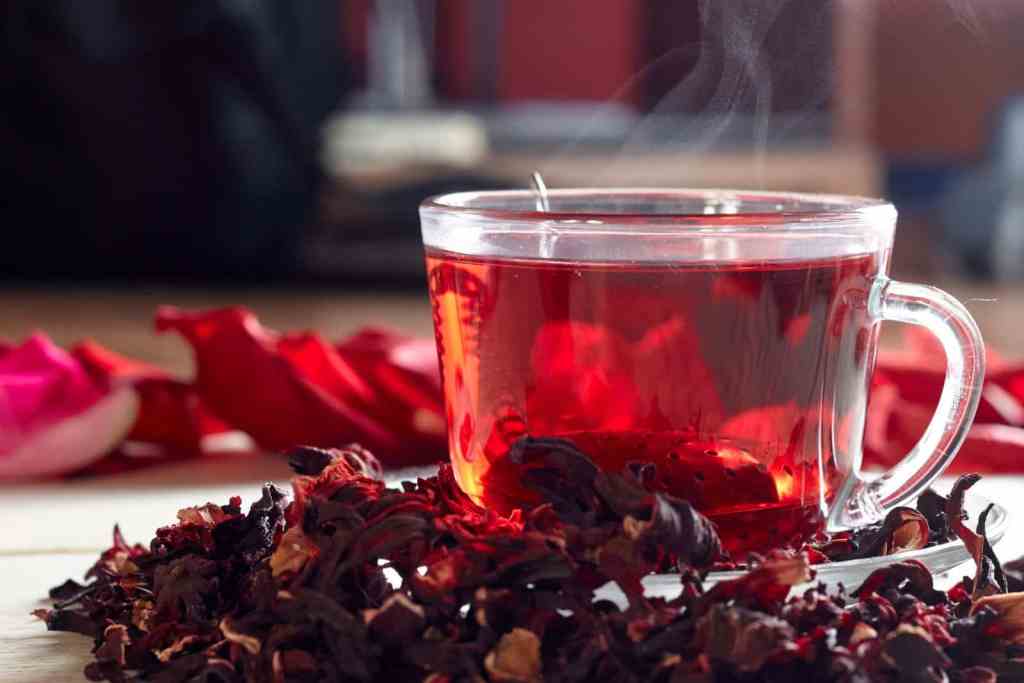 Hibiscus in Florida: Varieties, Care, Growth, Blooming, Landscaping, and Common Problems Steaming cup of red hibiscus tea with dried hibiscus calyces